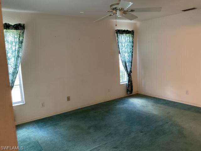 Empty room featuring carpet and ceiling fan