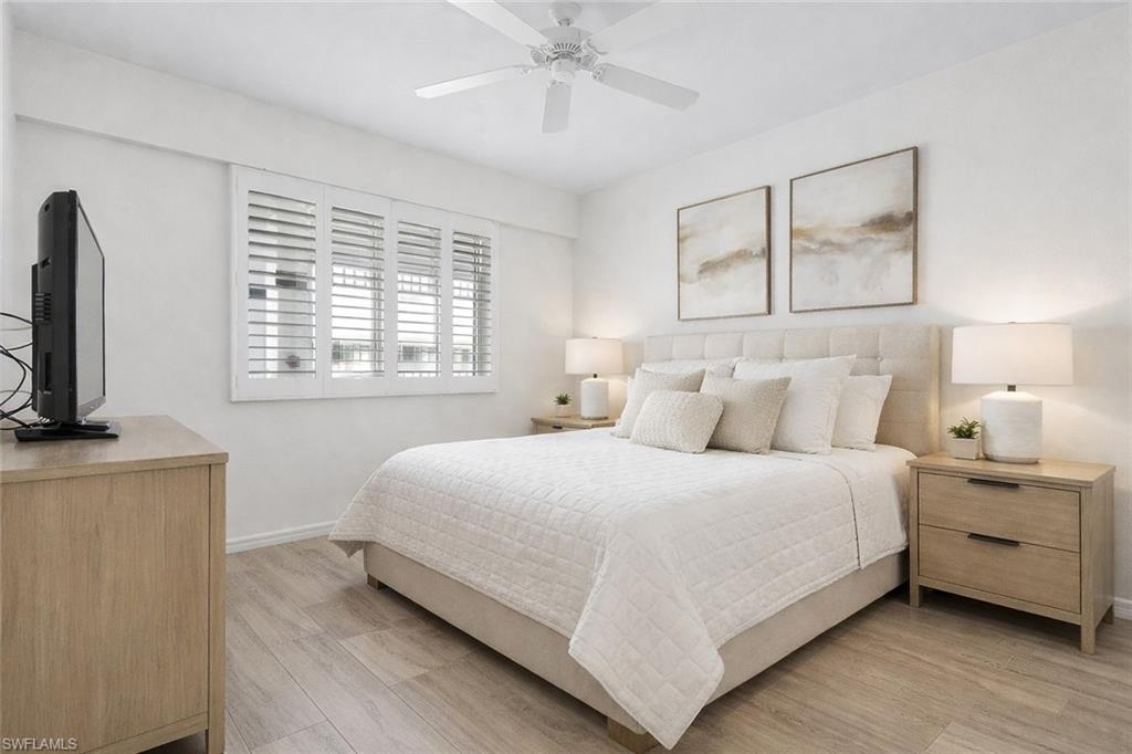 Virtual staged bedroom featuring light wood-style flooring and ceiling fan
