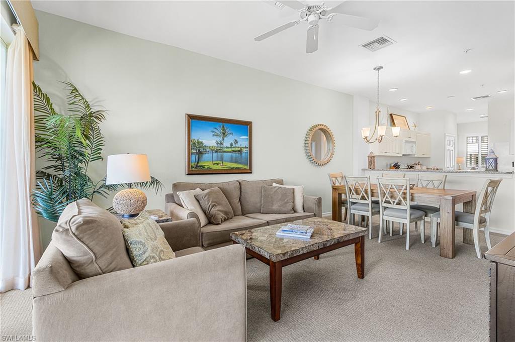 Living room with light carpet, recessed lighting, a ceiling fan, and a chandelier
