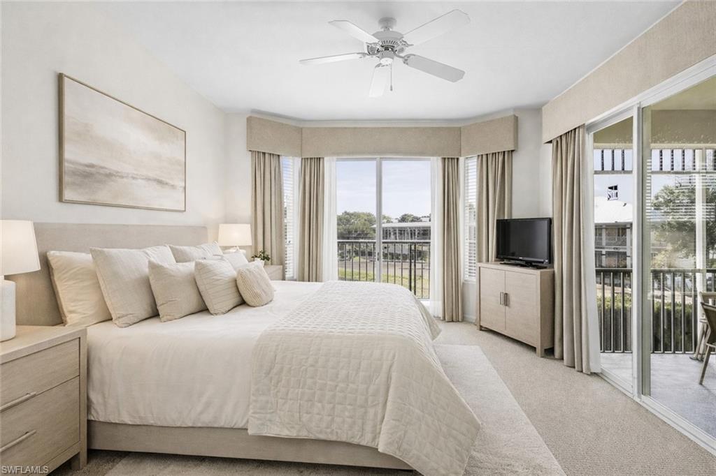 Virtual staged bedroom featuring access to exterior, light carpet, and ceiling fan