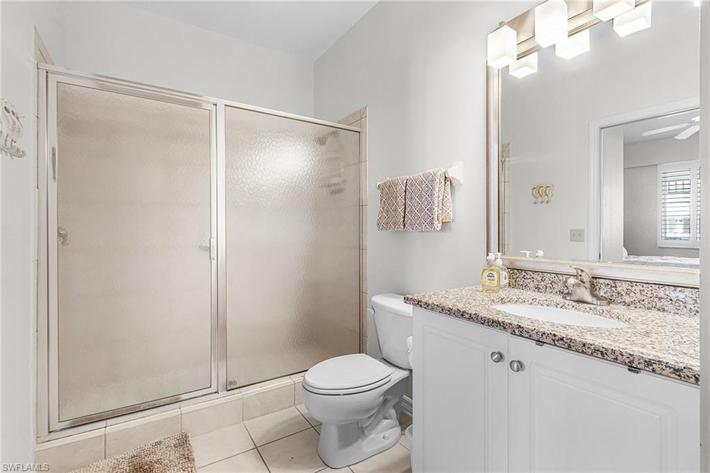 Bathroom with a stall shower, vanity, and light tile patterned floors