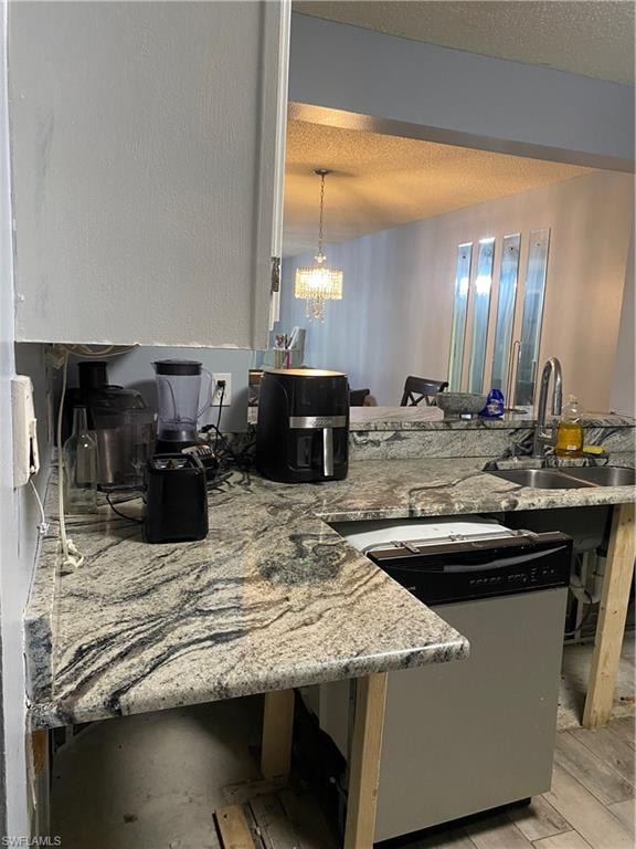 Kitchen featuring a kitchen breakfast bar, a peninsula, light stone countertops, dishwashing machine, and a chandelier