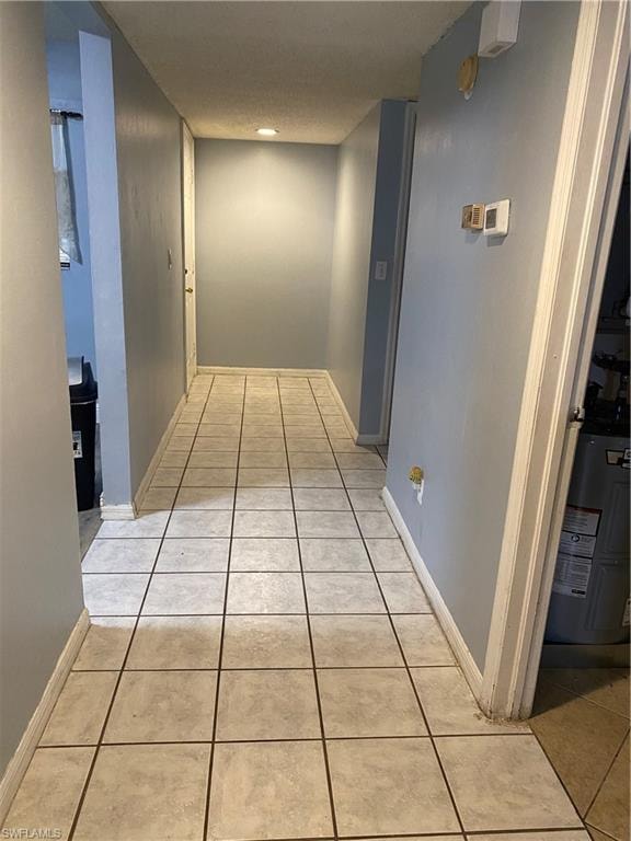 Hallway featuring light tile patterned floors and water heater