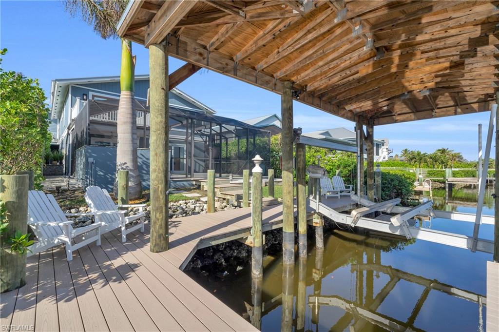 Dock area with a water view, boat lift, and a lanai