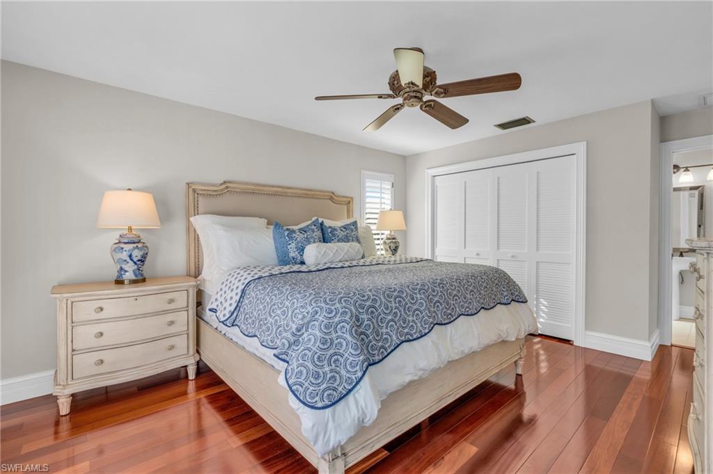 Bedroom with hardwood / wood-style floors, a closet, and a ceiling fan