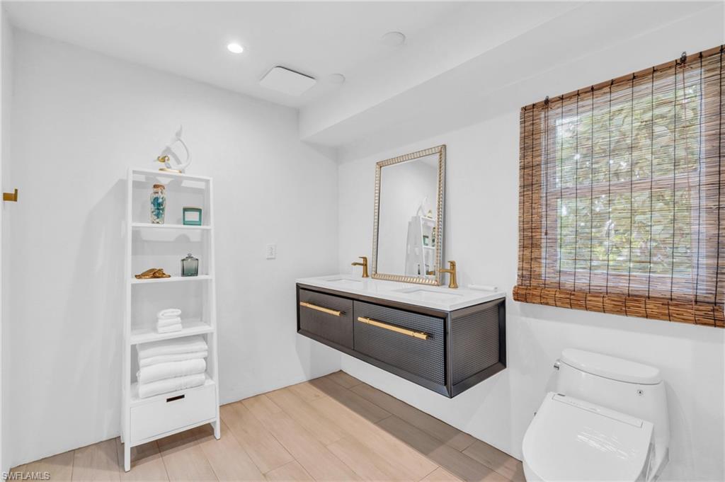 Full bathroom featuring double vanity, light wood-type flooring, and recessed lighting
