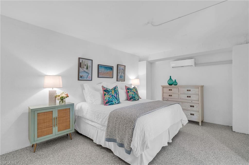 Carpeted bedroom with a wall mounted AC