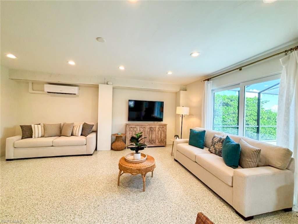 Living area featuring recessed lighting, speckled floor, and a wall mounted mini split