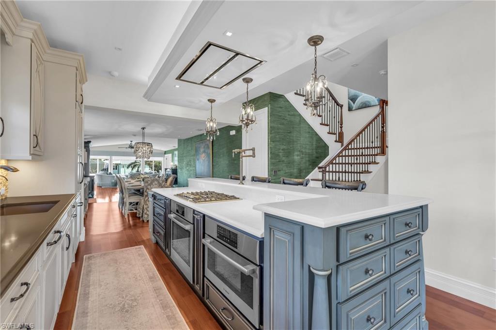 Kitchen with a chandelier, dark wood finished floors, decorative light fixtures, and blue cabinets