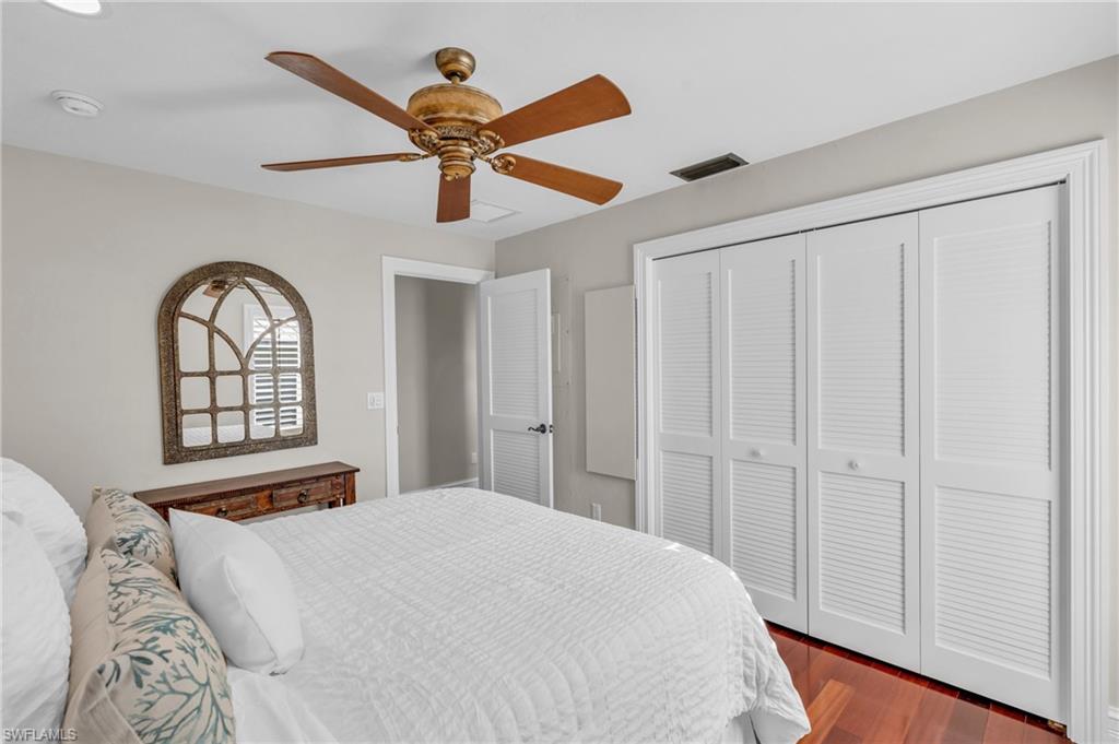 Bedroom featuring dark wood-type flooring, a ceiling fan, and a closet