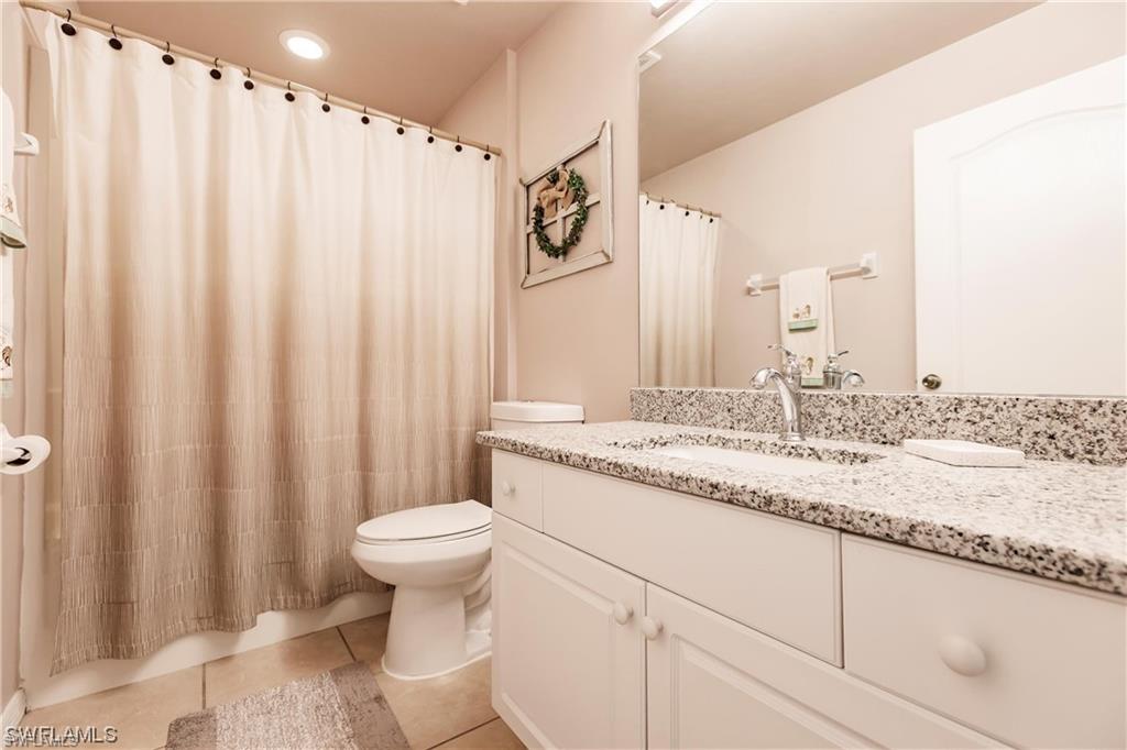 Bathroom featuring vanity, light tile patterned floors, and a shower with curtain