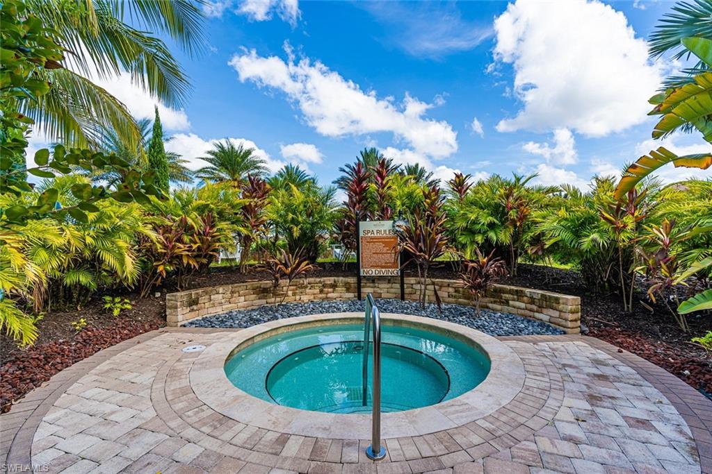 View of pool with a patio area and an in-ground hot tub