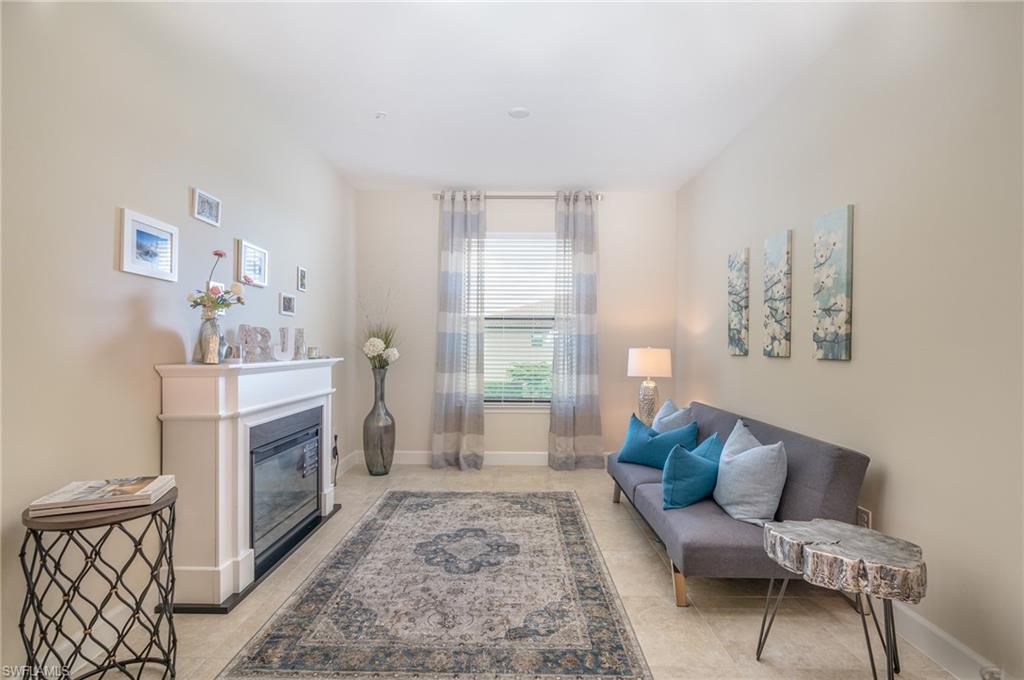 Living area featuring a glass covered fireplace and light tile patterned flooring