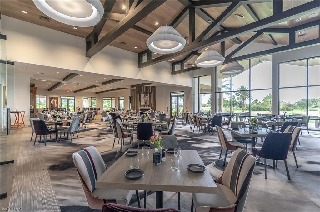 Dining space featuring beamed ceiling, a high ceiling, and recessed lighting