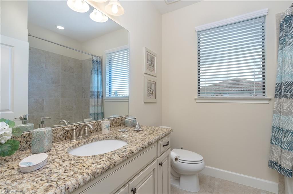 Full bath with vanity, light tile patterned floors, and a shower with curtain