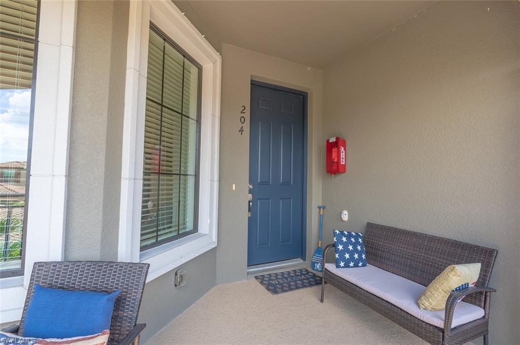 Entrance to property with covered porch and stucco siding