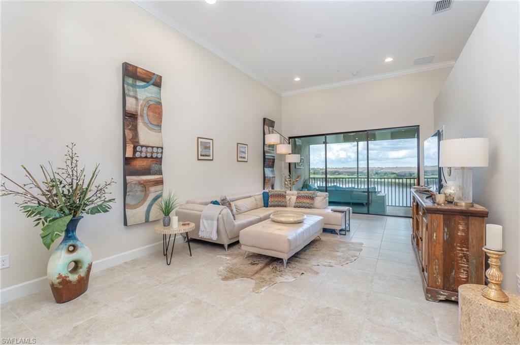 Living area with crown molding, recessed lighting, and light tile patterned floors