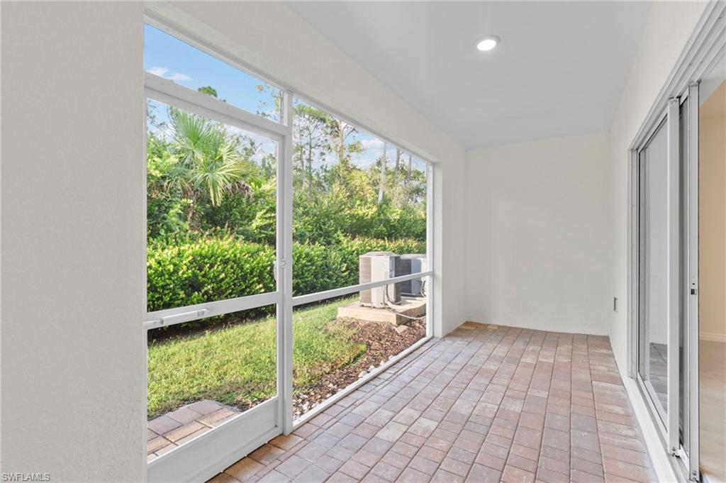 Unfurnished sunroom with brick flooring