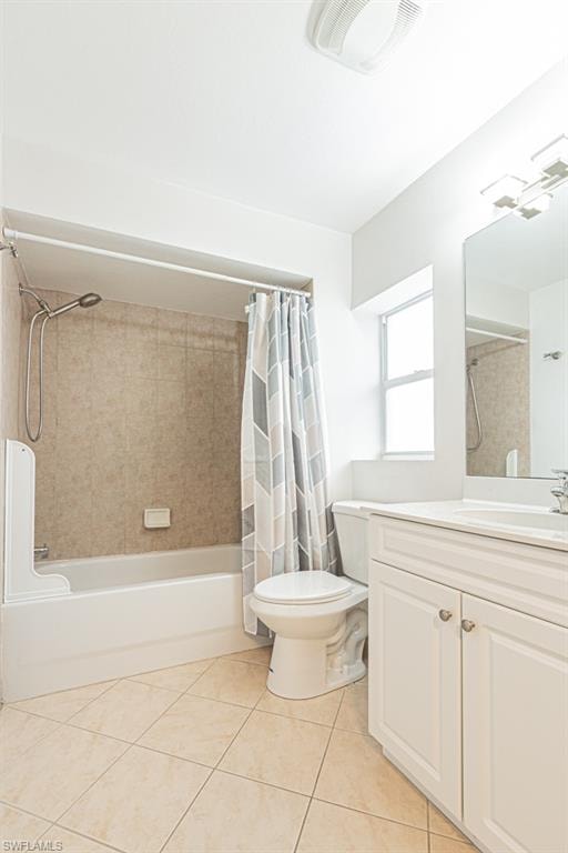 Bathroom with shower / bath combo with shower curtain, vanity, and light tile patterned flooring