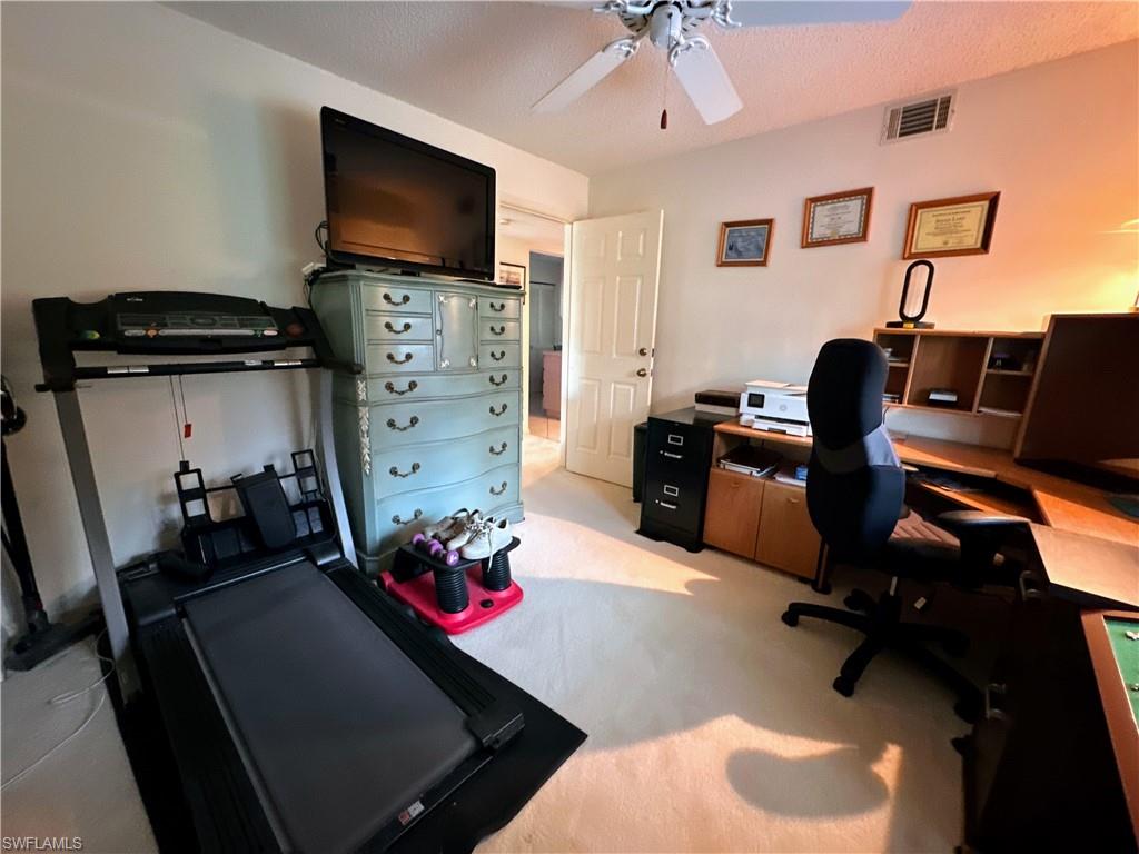 Office space with ceiling fan and light colored carpet