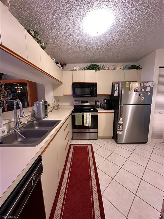 Kitchen with newer stainless steel appliances, light countertops,