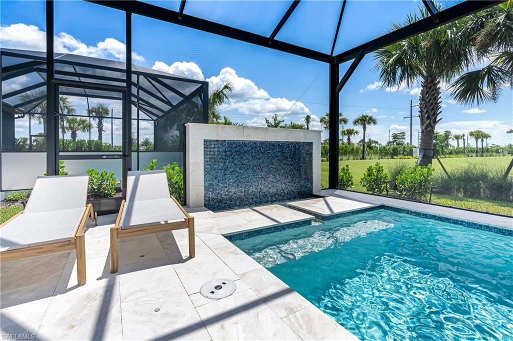 Outdoor pool featuring glass enclosure, a patio, and a sunroom