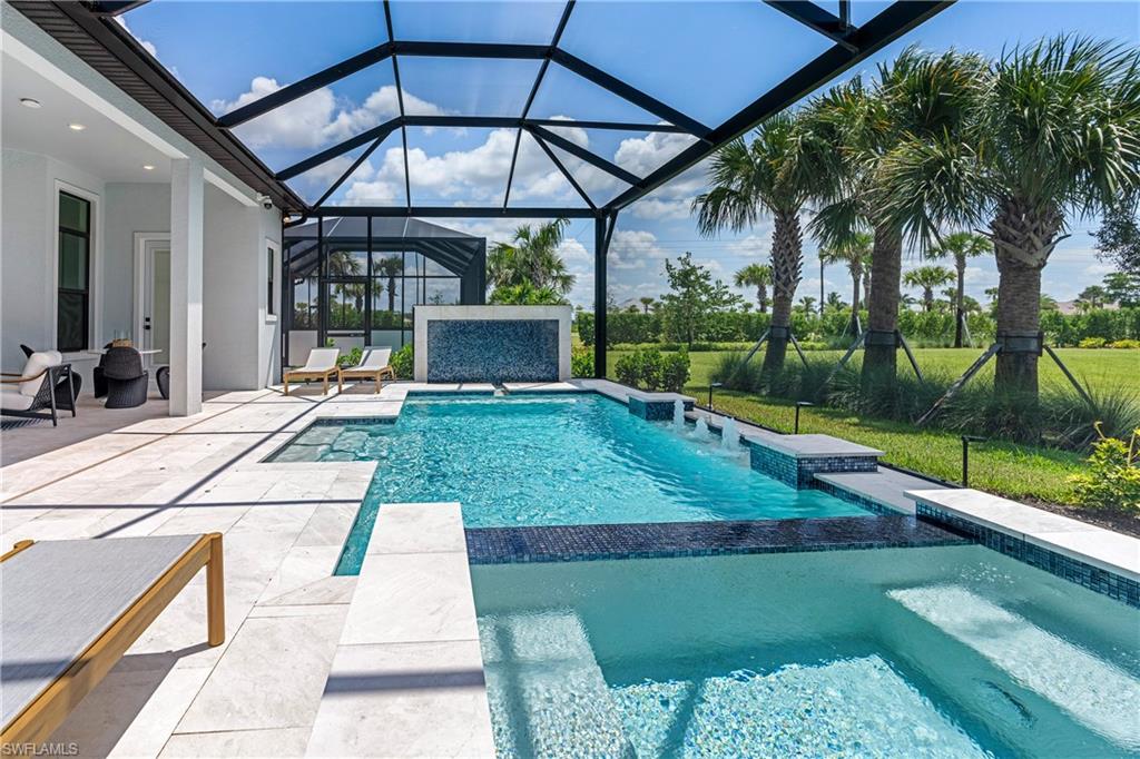 View of pool featuring a patio, a sunroom, a pool with connected hot tub, and a lanai