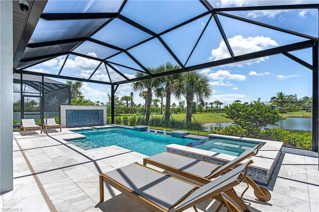 View of swimming pool with glass enclosure, a patio, a sunroom, a pool with connected hot tub, and a water view