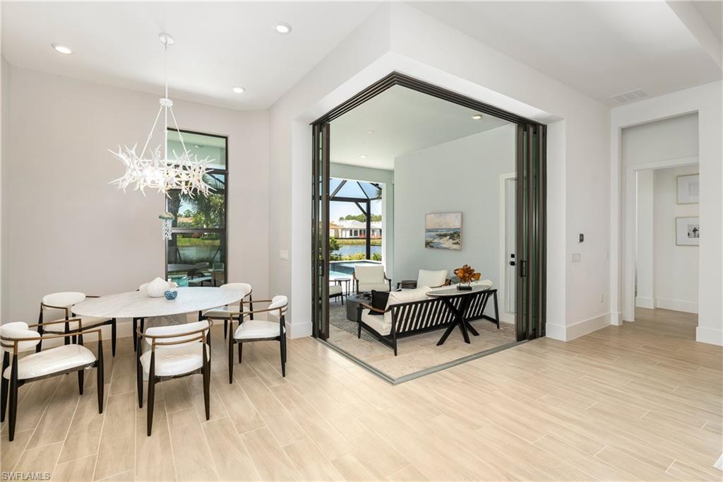 Dining area featuring a sunroom, recessed lighting, wood finish floors, a chandelier, and a water view