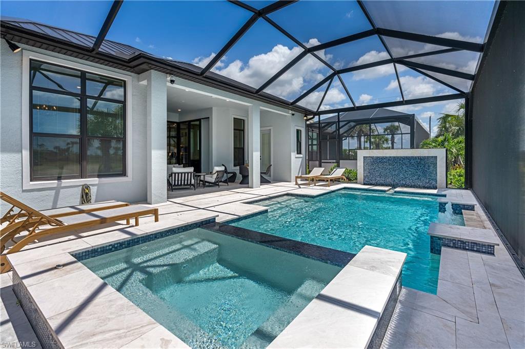 View of pool with a patio, a sunroom, glass enclosure, and a pool with connected hot tub