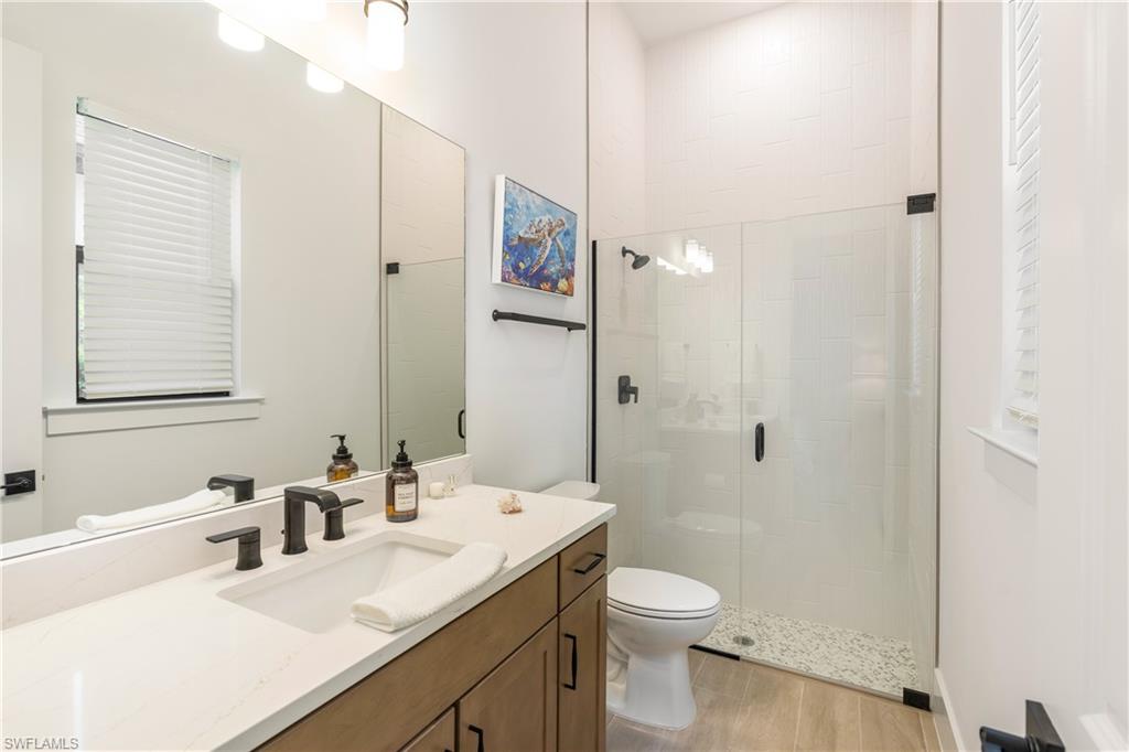 Bathroom with a stall shower, vanity, and light wood-type flooring