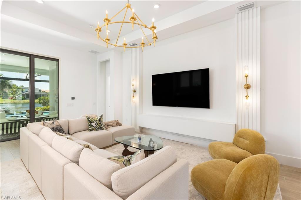 Living room with wood finished floors, recessed lighting, a chandelier, and a water view