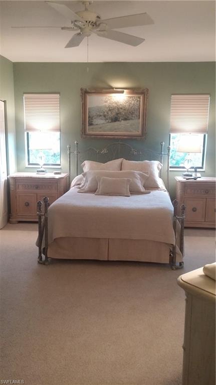 Bedroom with light colored carpet and a ceiling fan