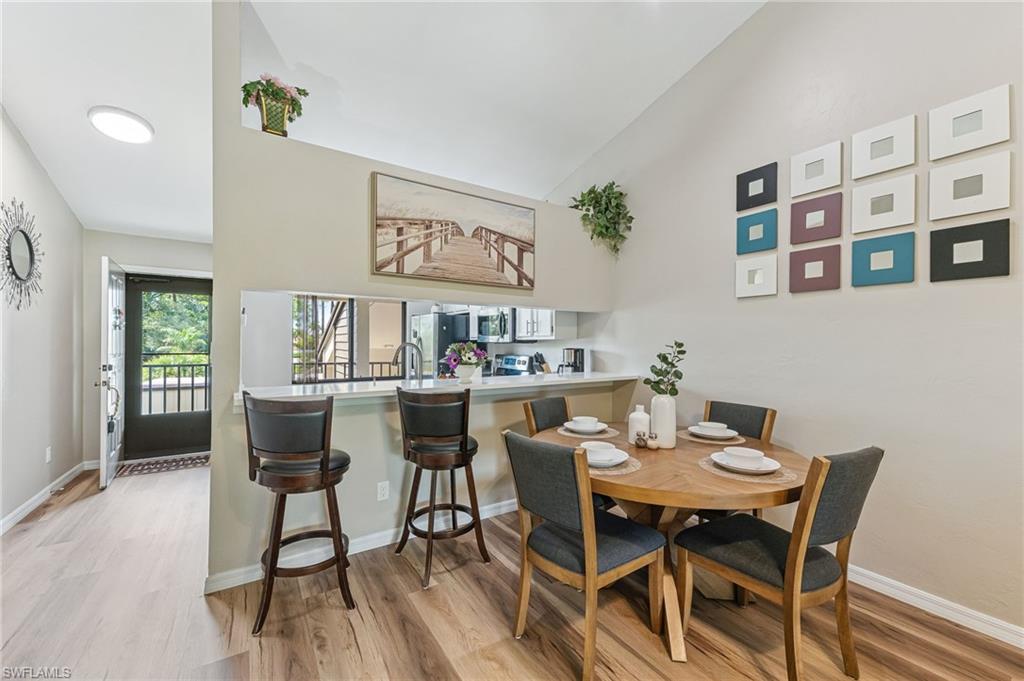 Dining space featuring light wood-type flooring and lofted ceiling