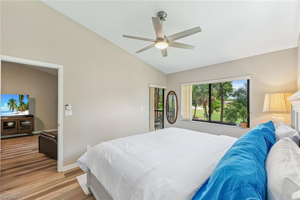 Bedroom with lofted ceiling, access to outside, light wood-style flooring, and a ceiling fan