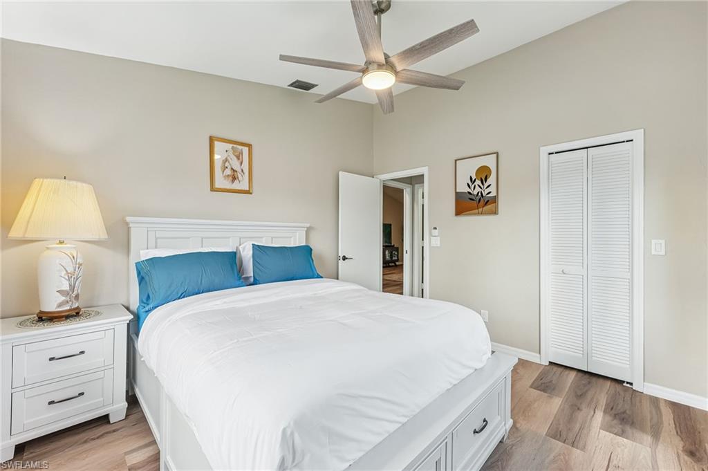 Bedroom featuring light wood finished floors, ceiling fan, and a closet