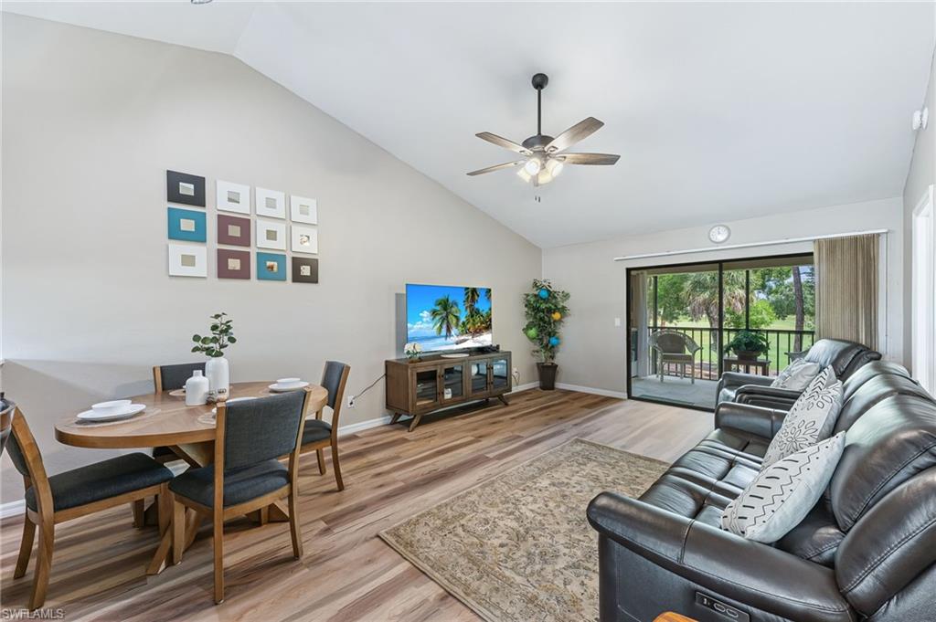 Living room featuring high vaulted ceiling, light wood finished floors, and ceiling fan