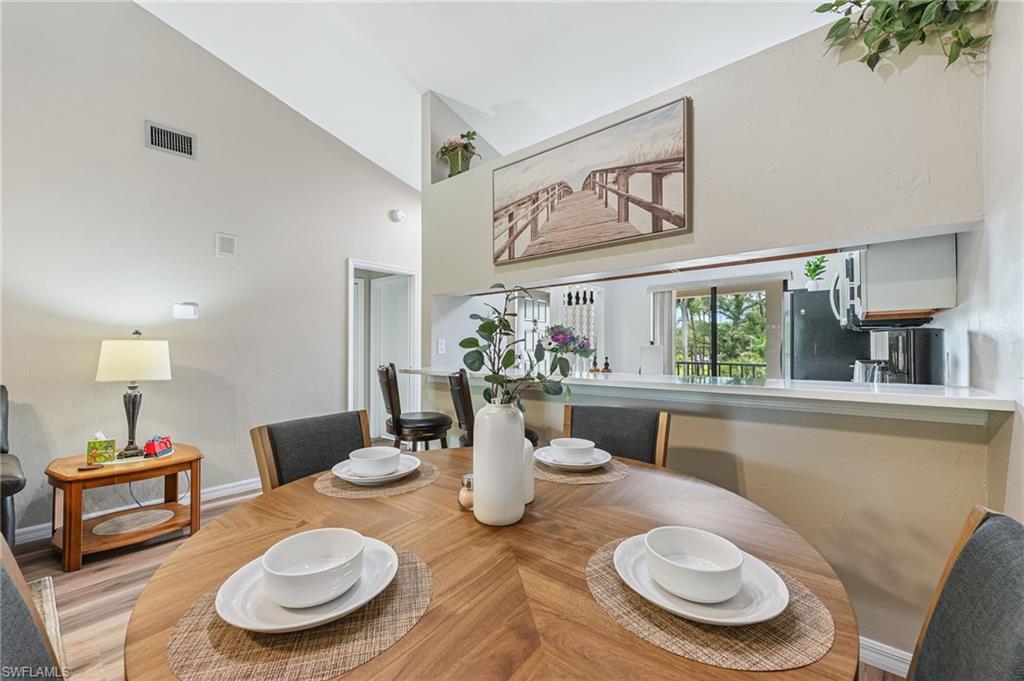 Dining space featuring wood finished floors and high vaulted ceiling