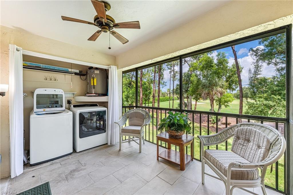 Sunroom featuring separate washer and dryer, electric water heater, golf course view, and a textured wall
