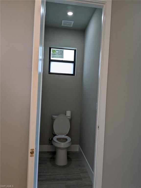 Great room with ceiling fan, light wood-style porcelain floors, a tray ceiling, and recessed lighting