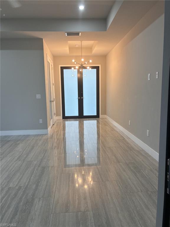 Entry with a chandelier, a raised ceiling, and recessed lighting