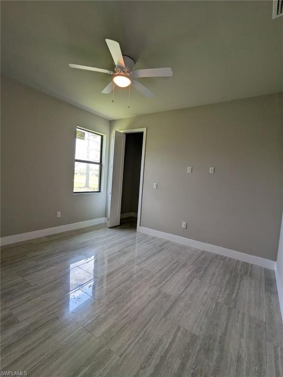 Bedroom featuring ceiling fan and light wood-style porcelain floors.