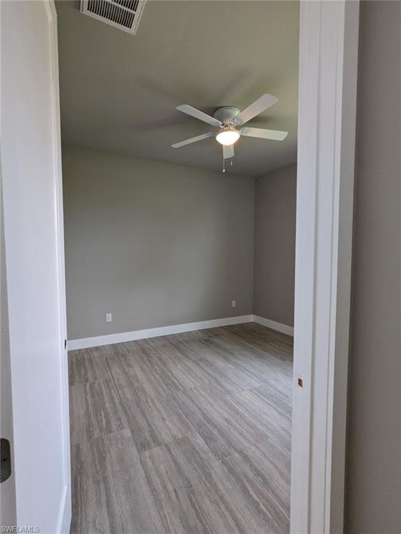 Bedroom with light wood-type porcelain flooring and a ceiling fan.