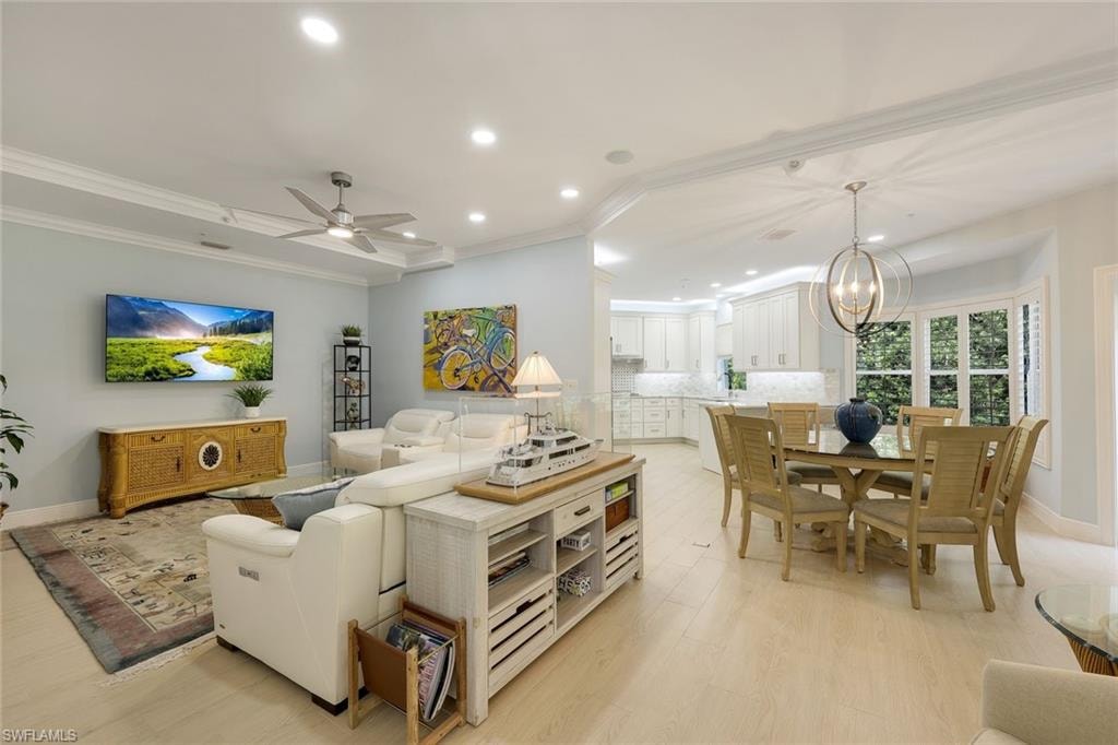 Living area with recessed lighting, crown molding, a chandelier, a ceiling fan, and light wood-type flooring