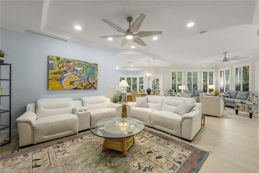 Living area featuring crown molding, ceiling fan, recessed lighting, and wood finished floors