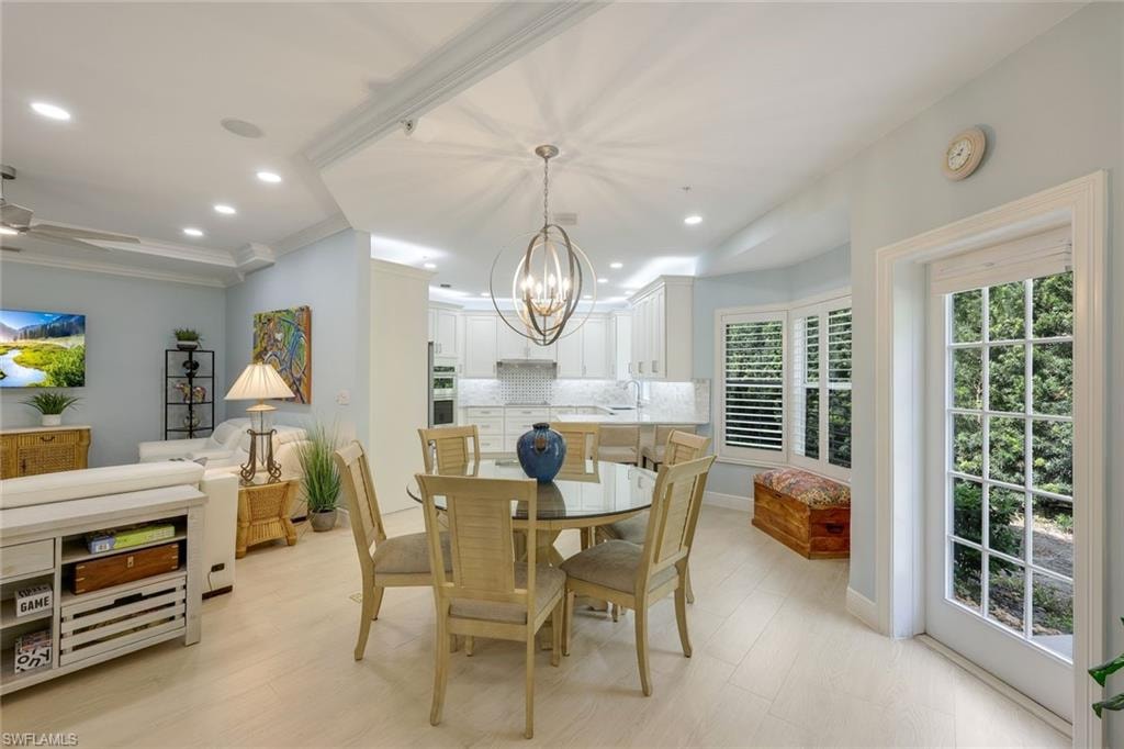 Dining space with recessed lighting, light wood finished floors, a chandelier, ornamental molding, and ceiling fan