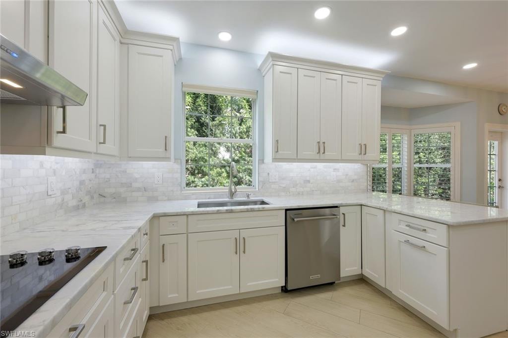Kitchen featuring black electric cooktop, healthy amount of natural light, stainless steel dishwasher, recessed lighting, and a peninsula