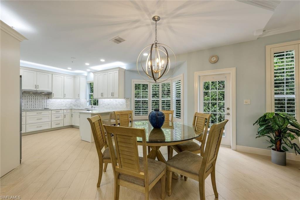 Dining area featuring light wood-style floors, a chandelier, and recessed lighting