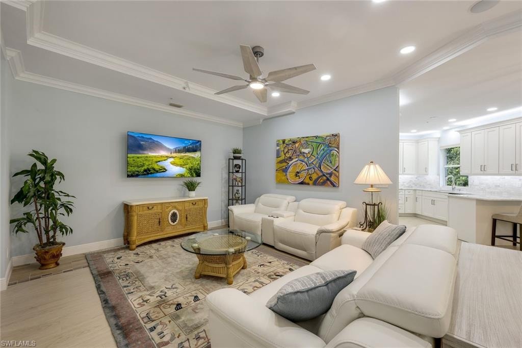 Living area featuring ornamental molding, light wood finished floors, recessed lighting, and a ceiling fan