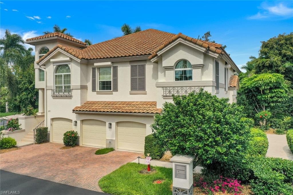 Mediterranean / spanish-style house featuring a garage, decorative driveway, stucco siding, and a tile roof